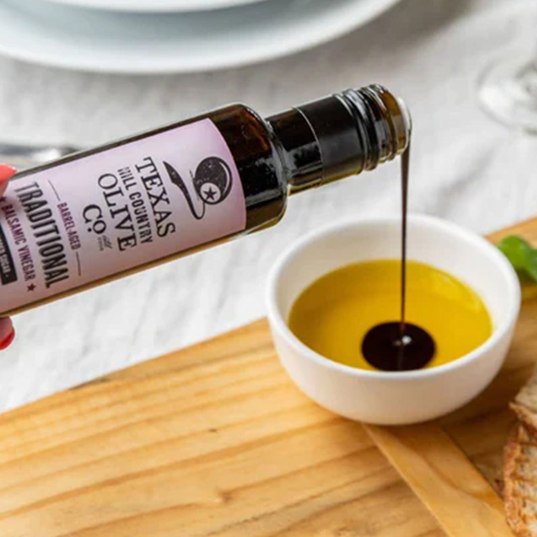 Traditional Aged Balsamic Vinegar poured into a white bowl of golden olive oil for dipping.