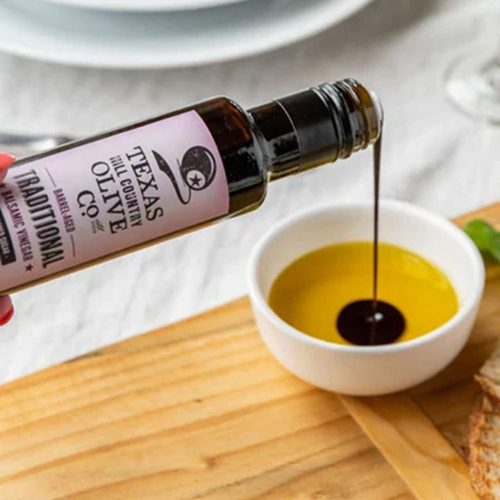 Traditional Aged Balsamic Vinegar poured into a white bowl of golden olive oil for dipping.